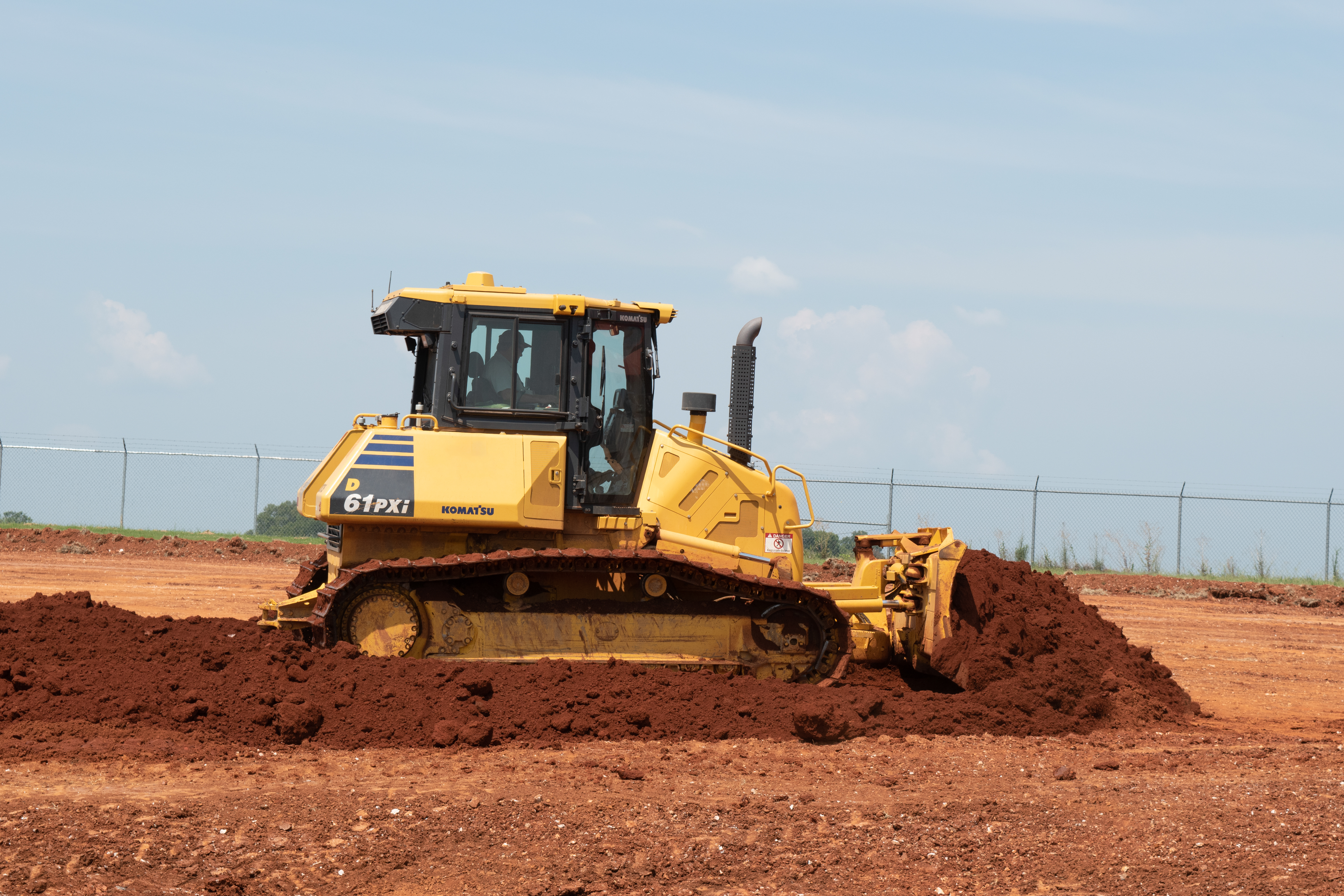Yellow dozer at construction site under blue sky