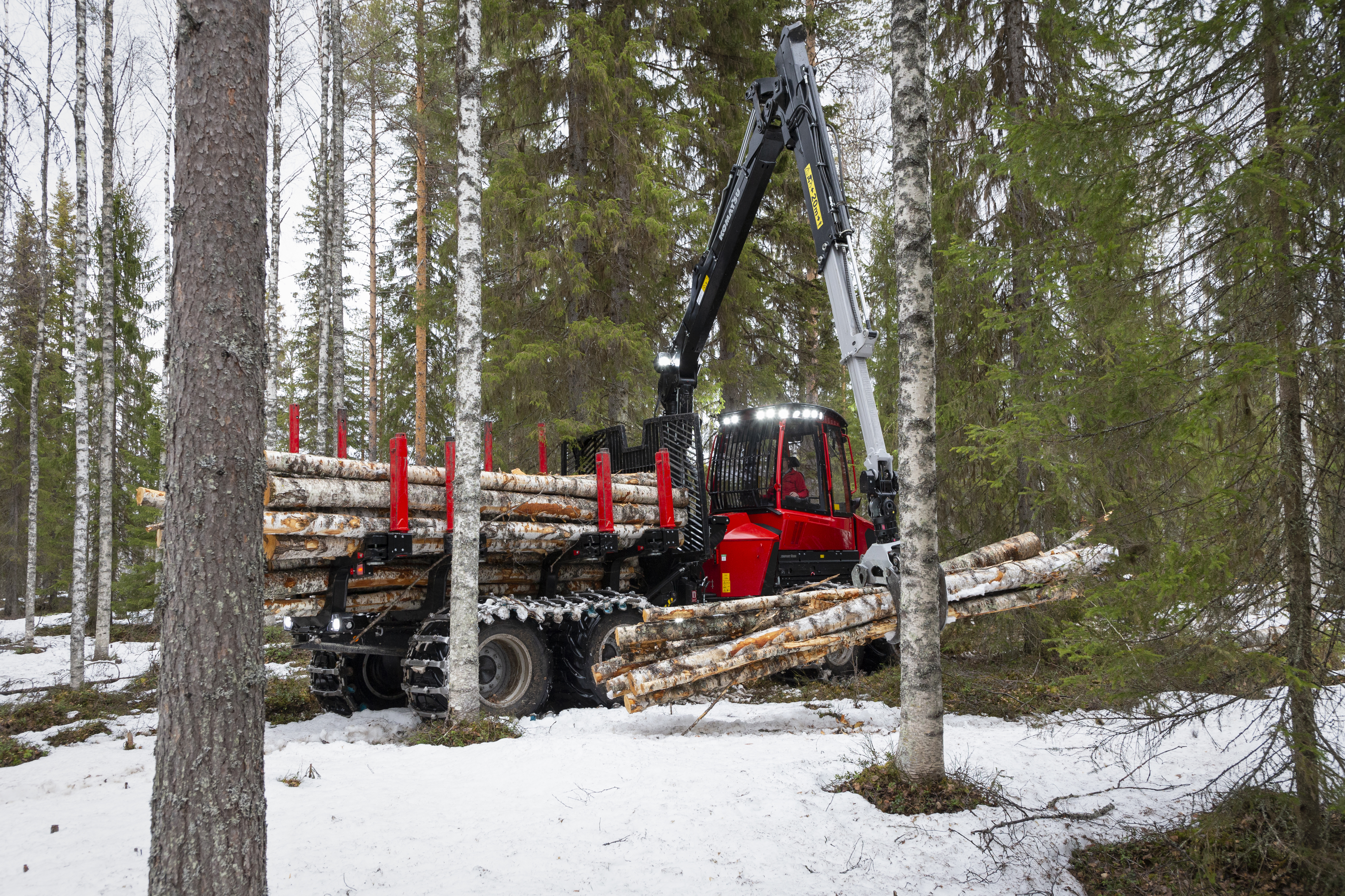 Komatsu 845 forwarder lifting log in forest