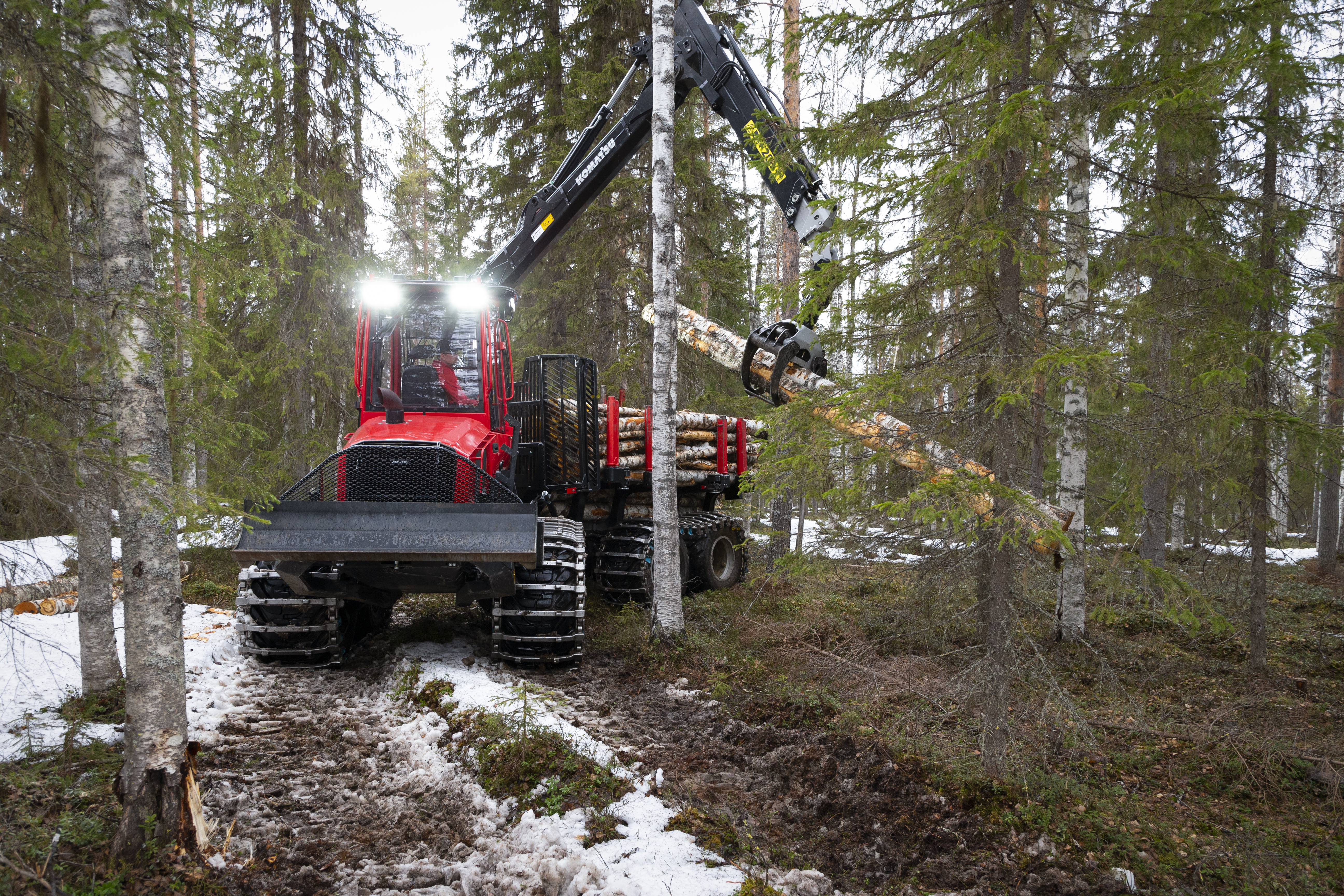 Komatsu 845 forwarder lifting log in forest
