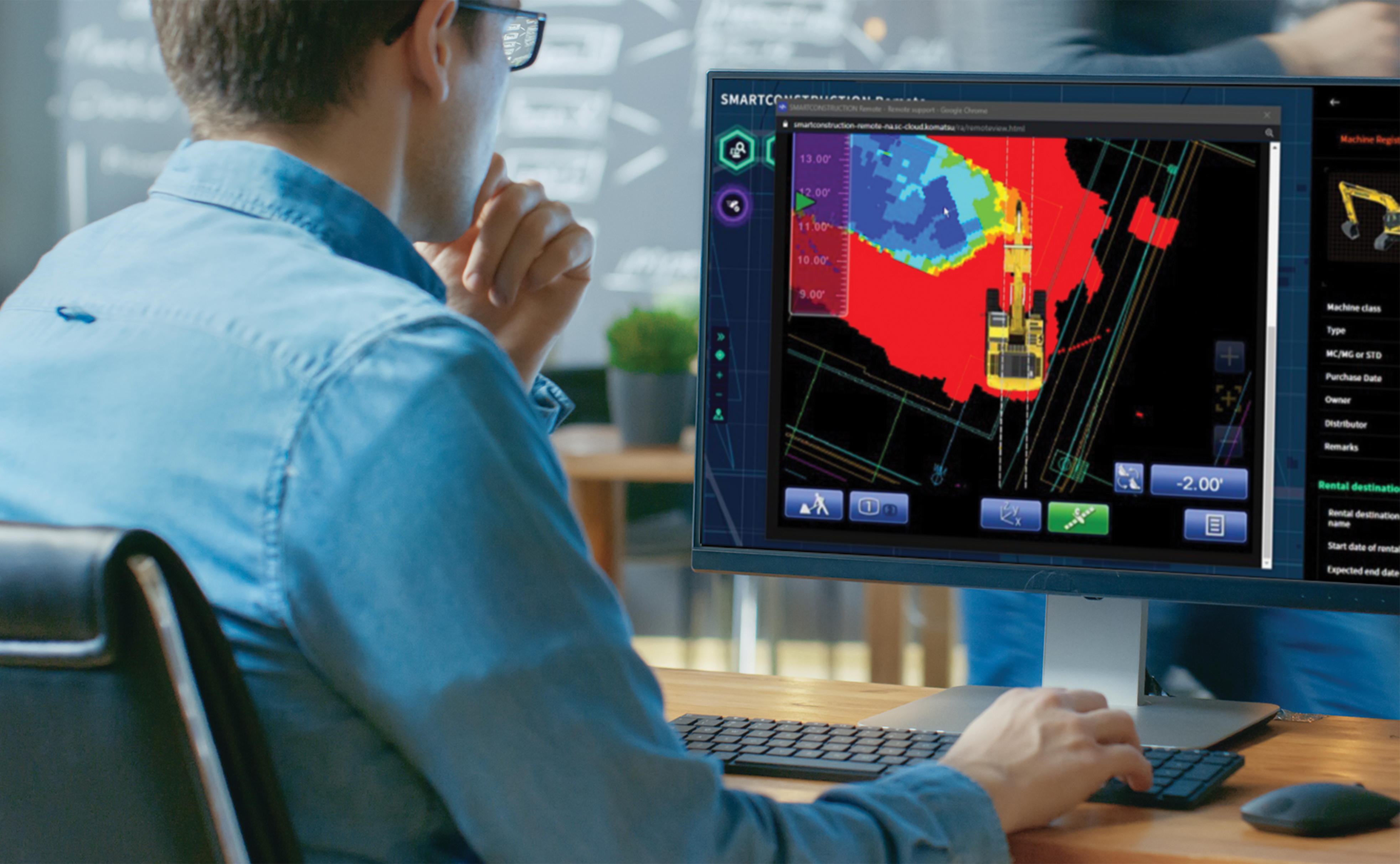 Person seated at a desk using Smart Construction Remote software on a computer monitor
