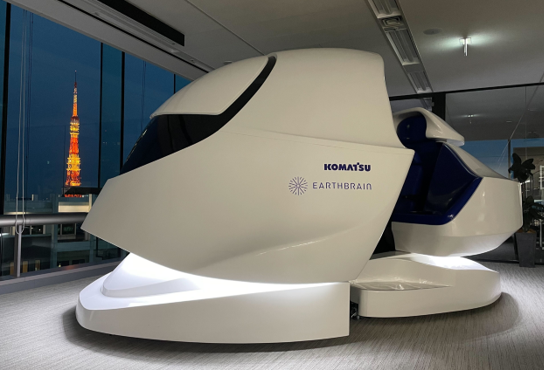 Large white vehicle cockpit displayed in a modern office at night