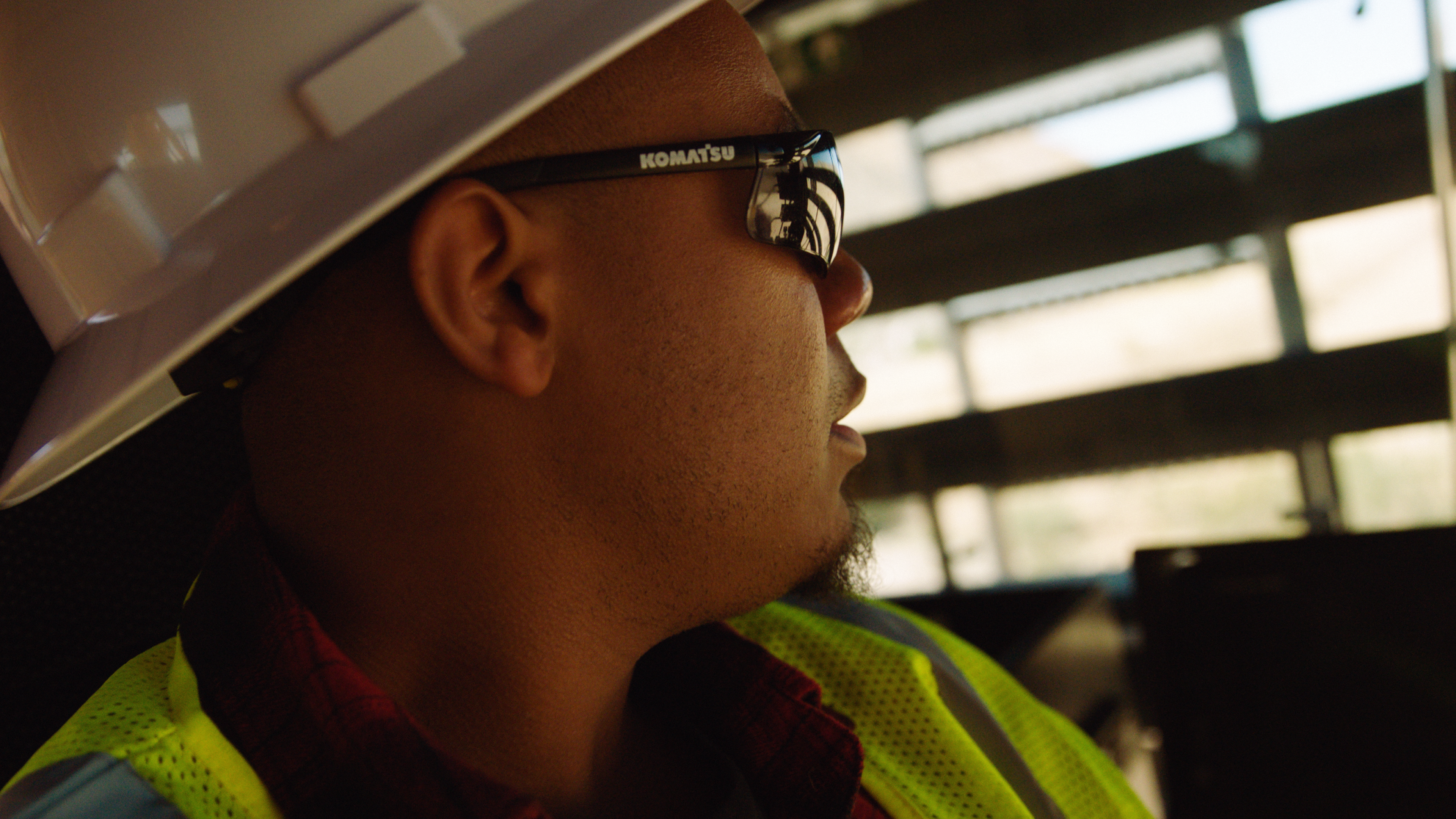 Man in construction hat gazes out window