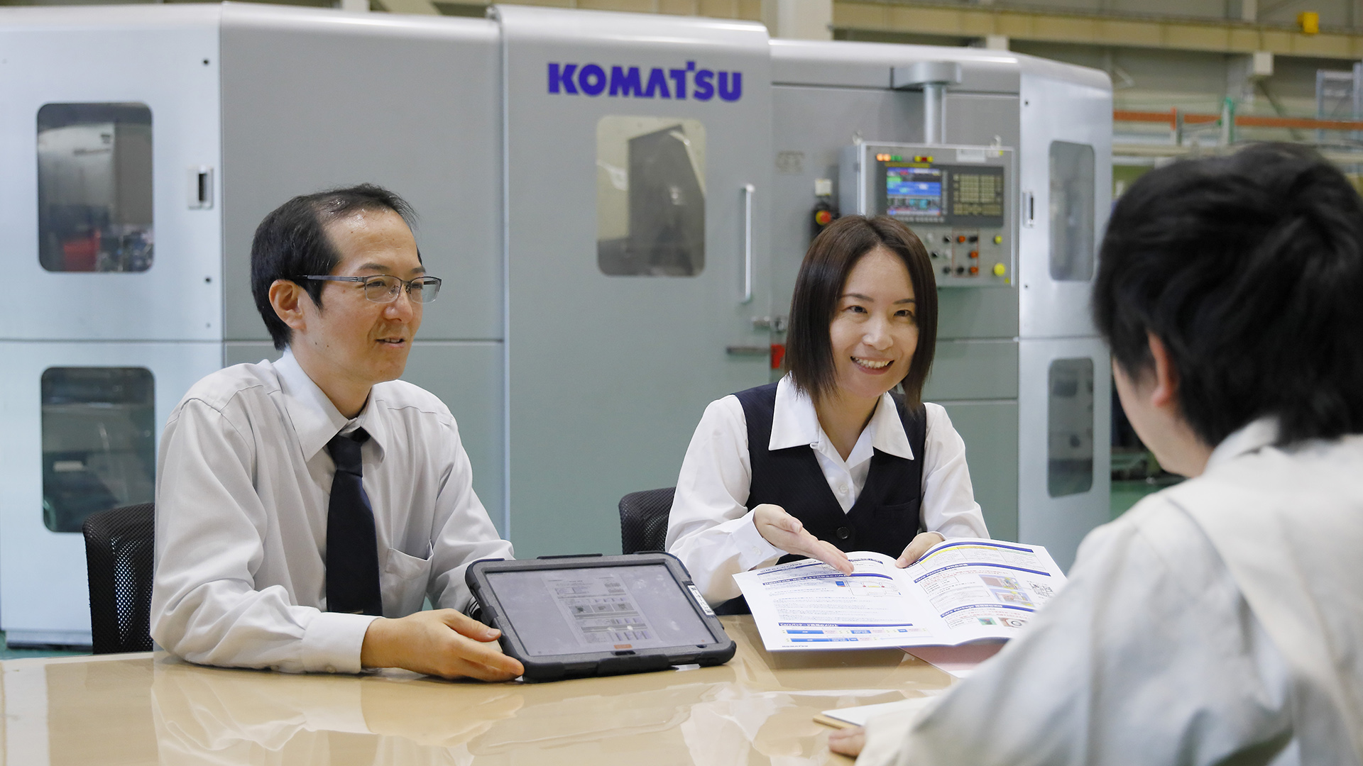 Business meeting near Komatsu machinery