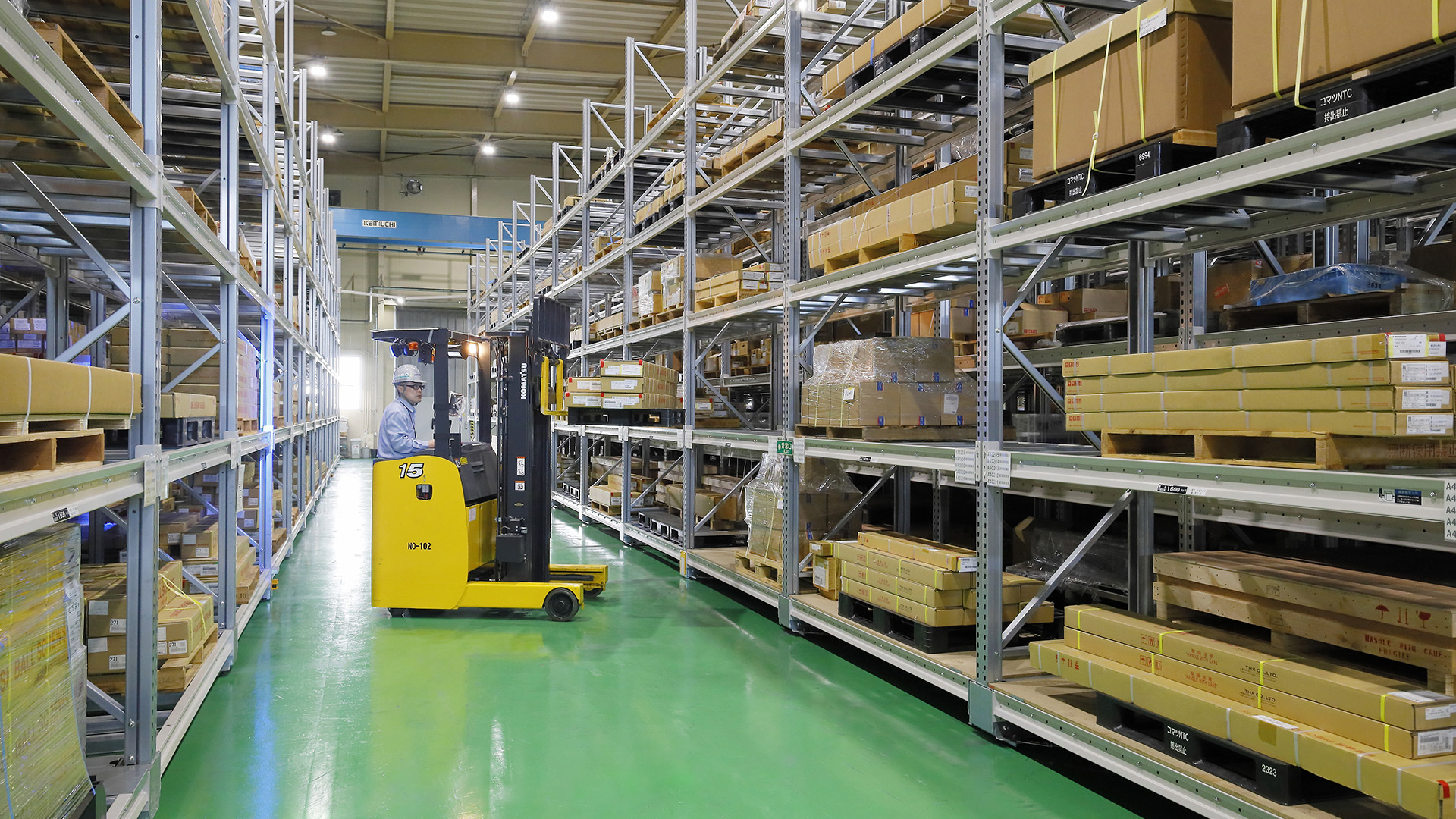 Warehouse worker operating yellow forklift