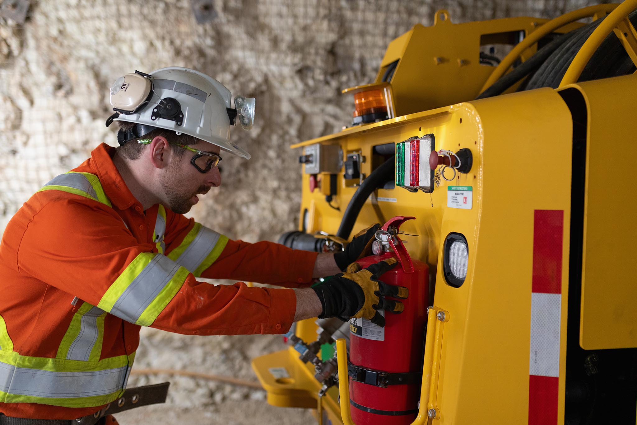 Worker servicing underground mining equipment inside a mine.