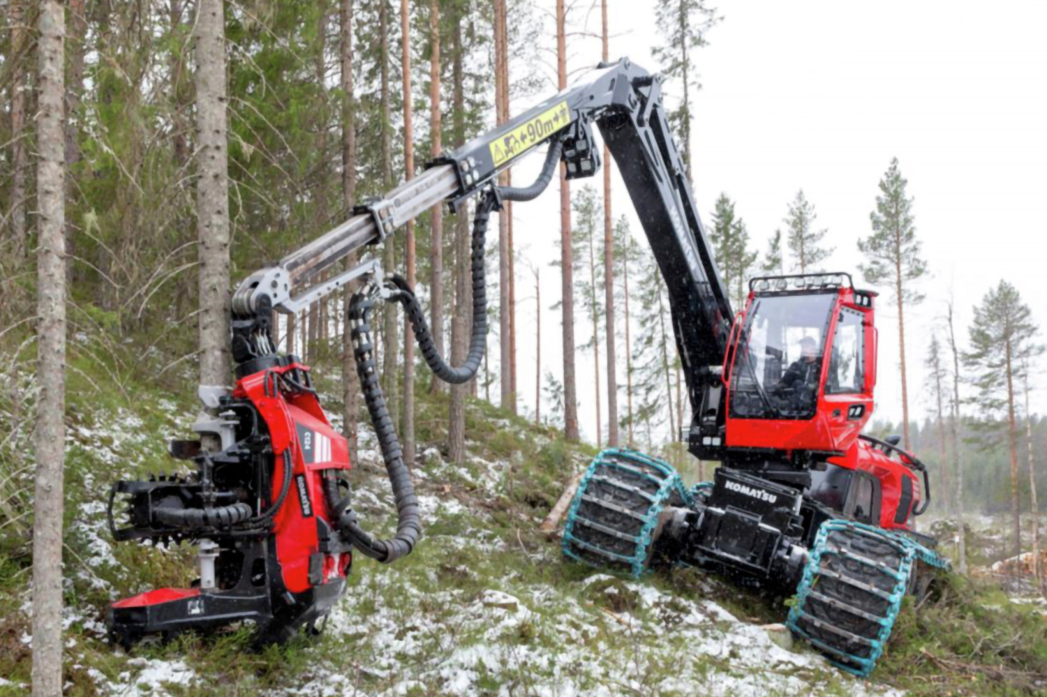 Forestry harvester clearing logs in a forest in winter