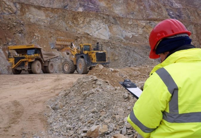 عامل يراقب معدات ثقيلة في موقع محجر