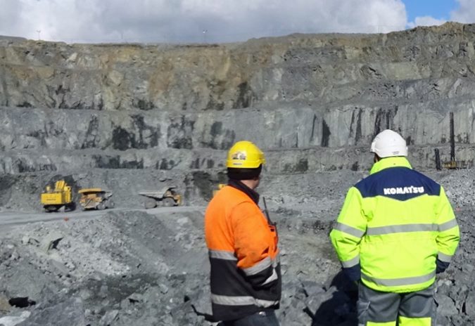 عمال في موقع محجر مع معدات Komatsu