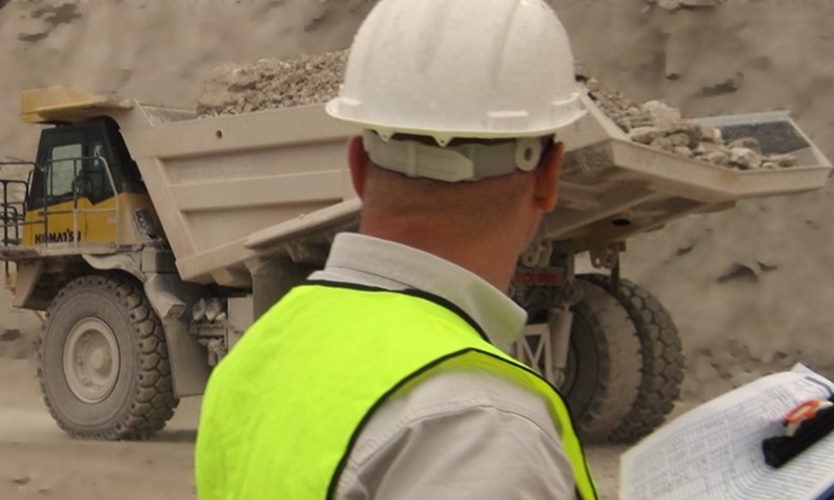 عامل بناء بالقرب من شاحنة تفريغ ثقيلة