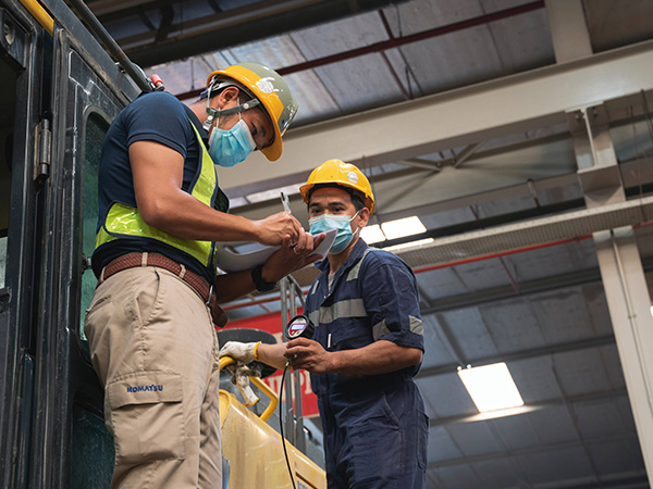 عمال يفحصون المعدات في موقع صناعي