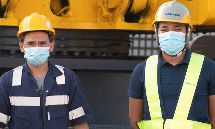 عمال بناء بالقرب من معدات ثقيلة