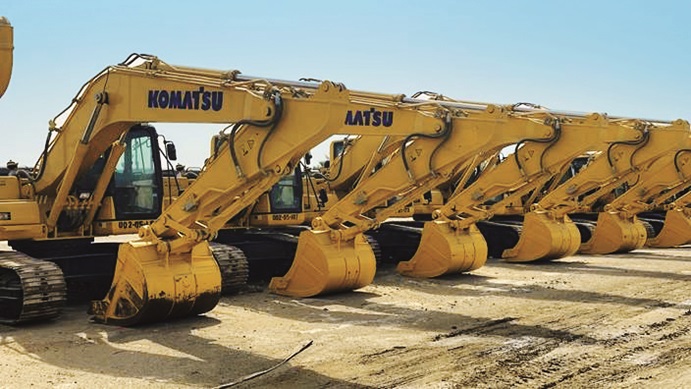 A fleet of Bin Quraya's yellow construction excavators lined up in a row at an equipment yard.