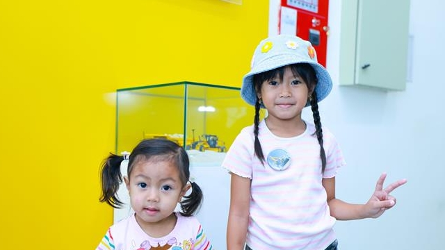 فتاتان تقفان داخل المنزل بالقرب من خزانة عرض