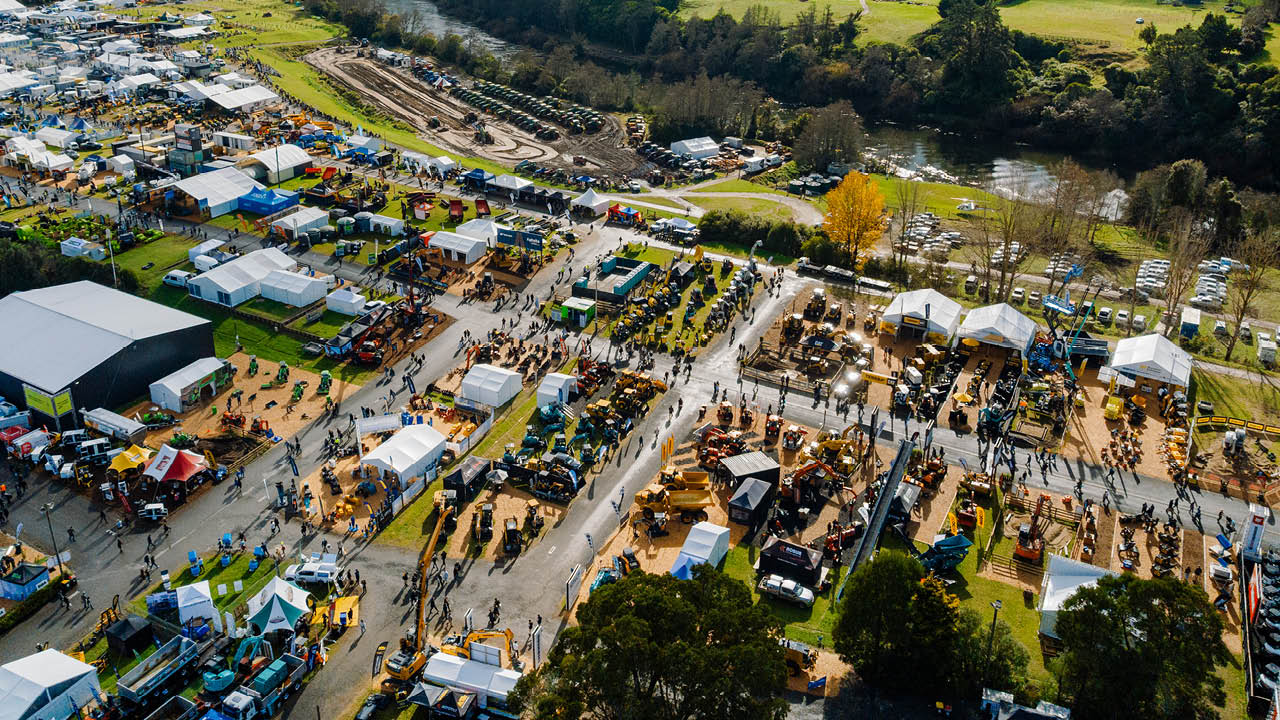 Aerial view of a large outdoor event, showcasing crowds, tents, and activities in a vibrant setting.