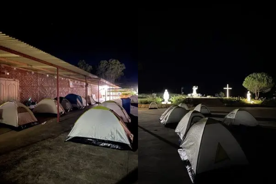 Rows of camping tents set up outdoors at night