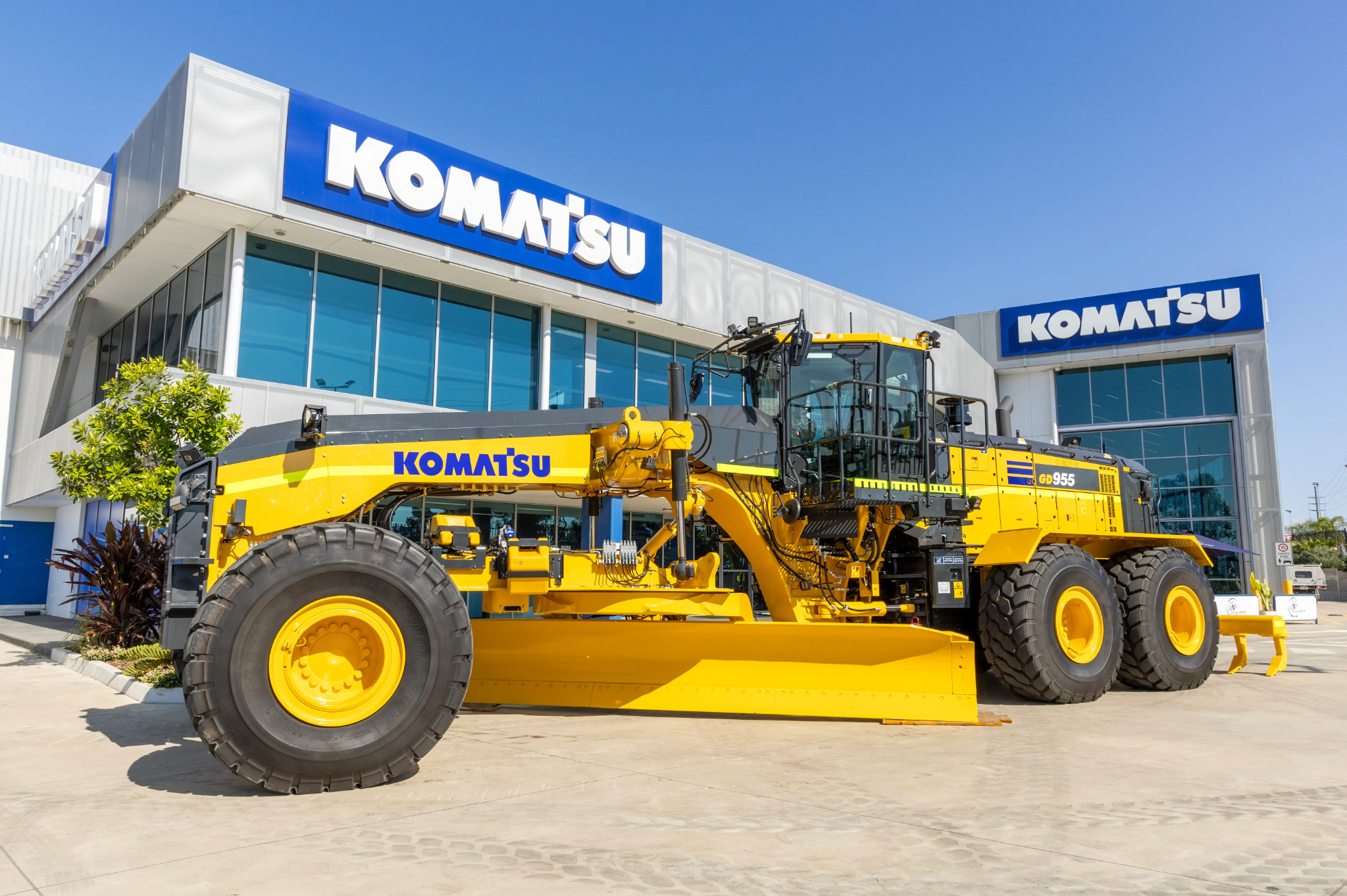 Komatsu GD955-7 grader in front of building