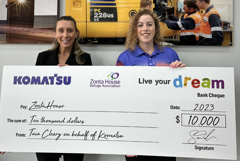 Komatsu employee and Zonta House employee standing with Komatsu Live Your Dream cheque
