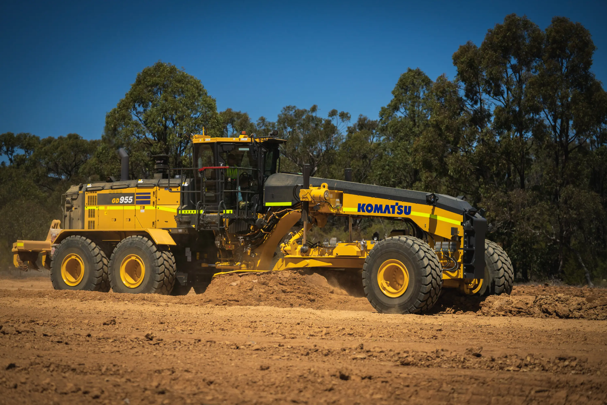 Grading machine pushing dirt on worksite