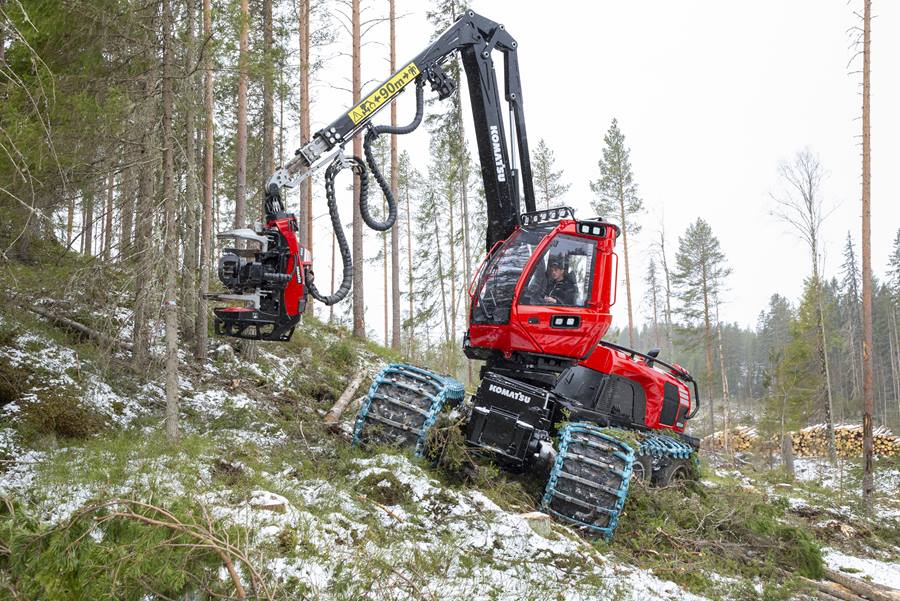 Forestry machine harvesting trees in snowy forest