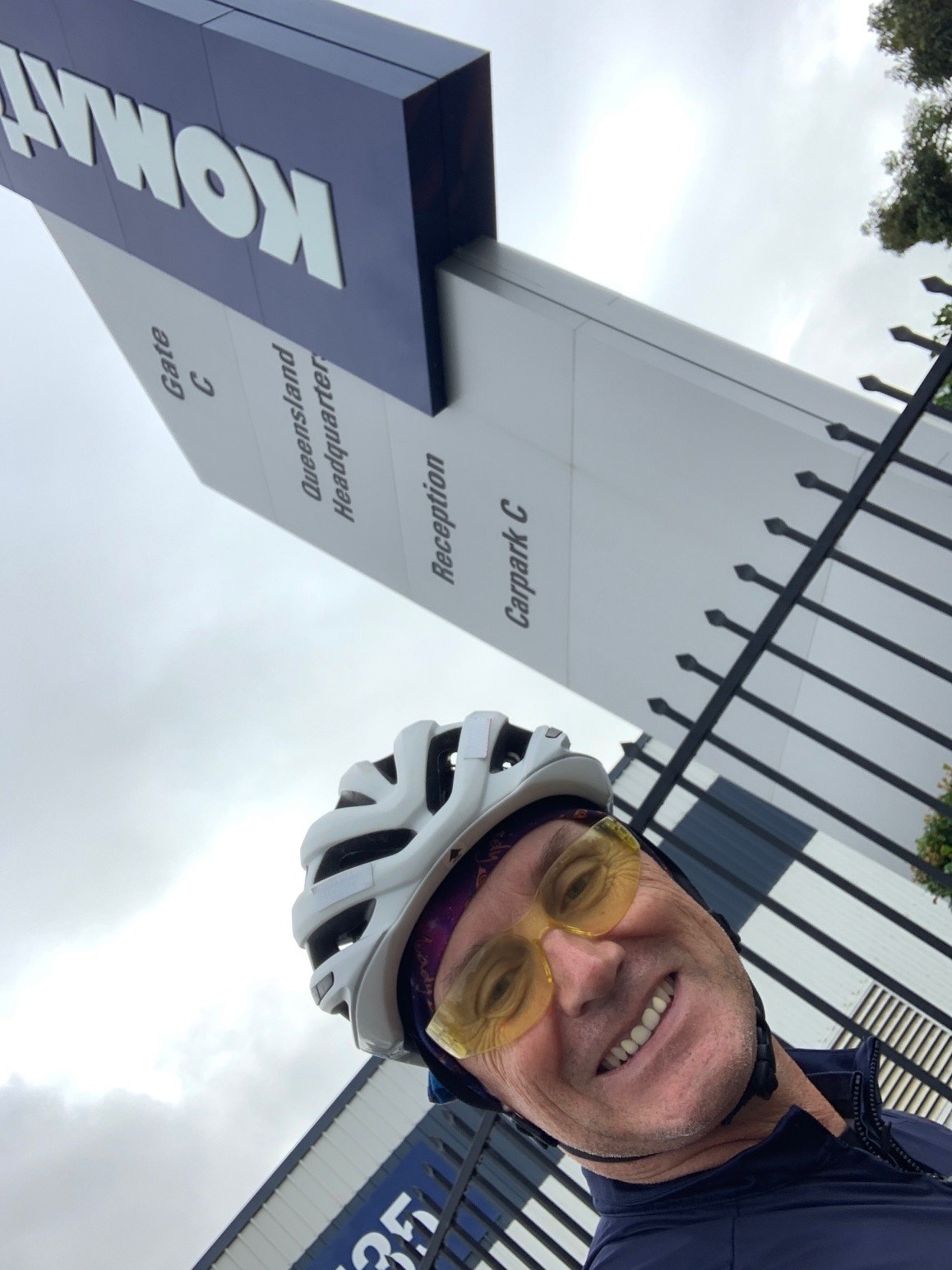 Cyclist near Komatsu building signage