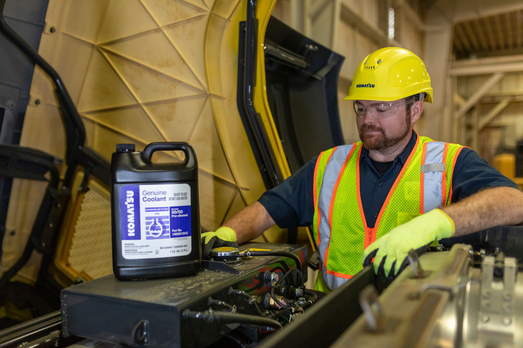 Worker with Komatsu Genuine Coolant in workshop