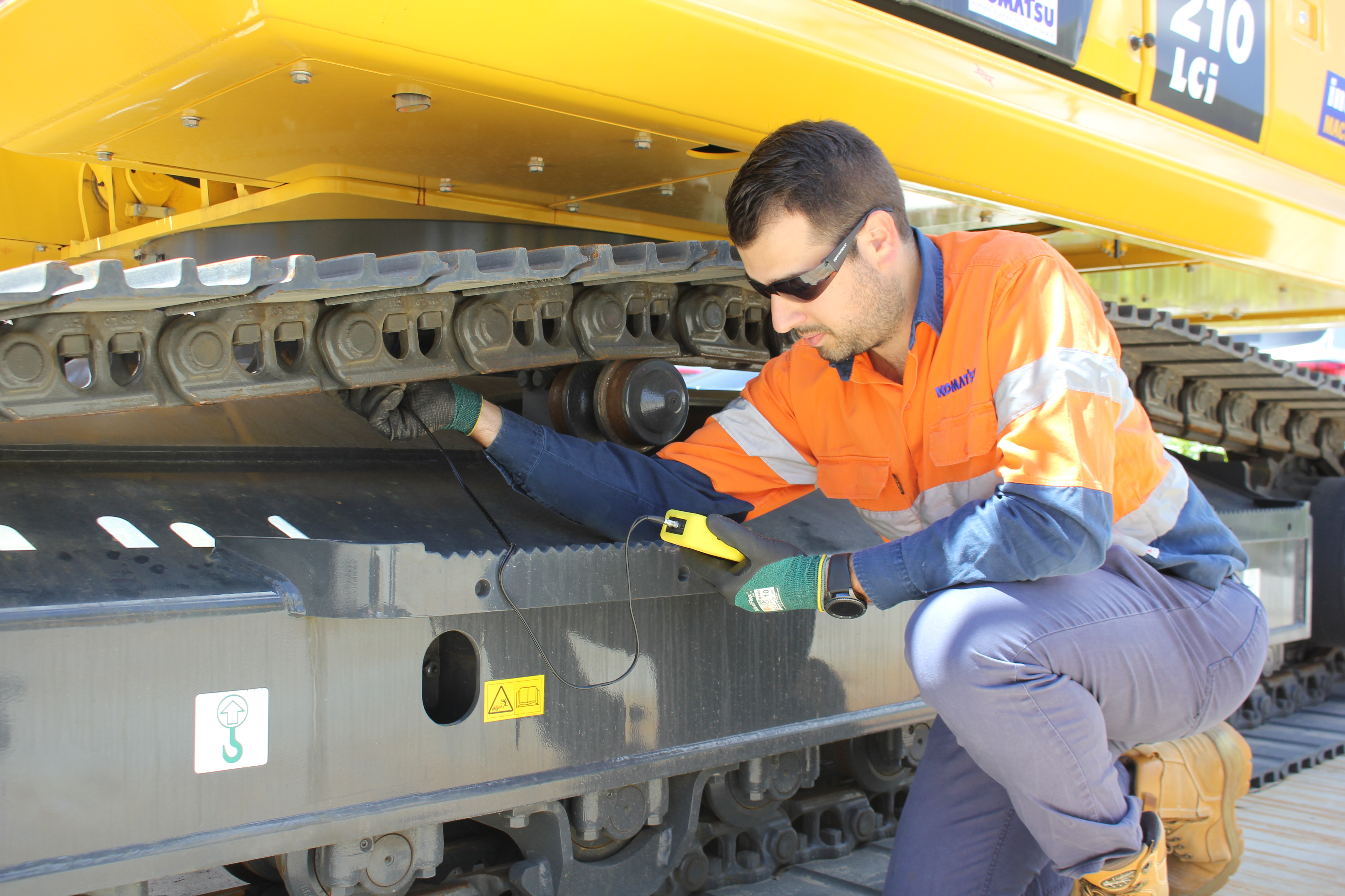 Genuine undercarriage inspection on a Komatsu excavator.