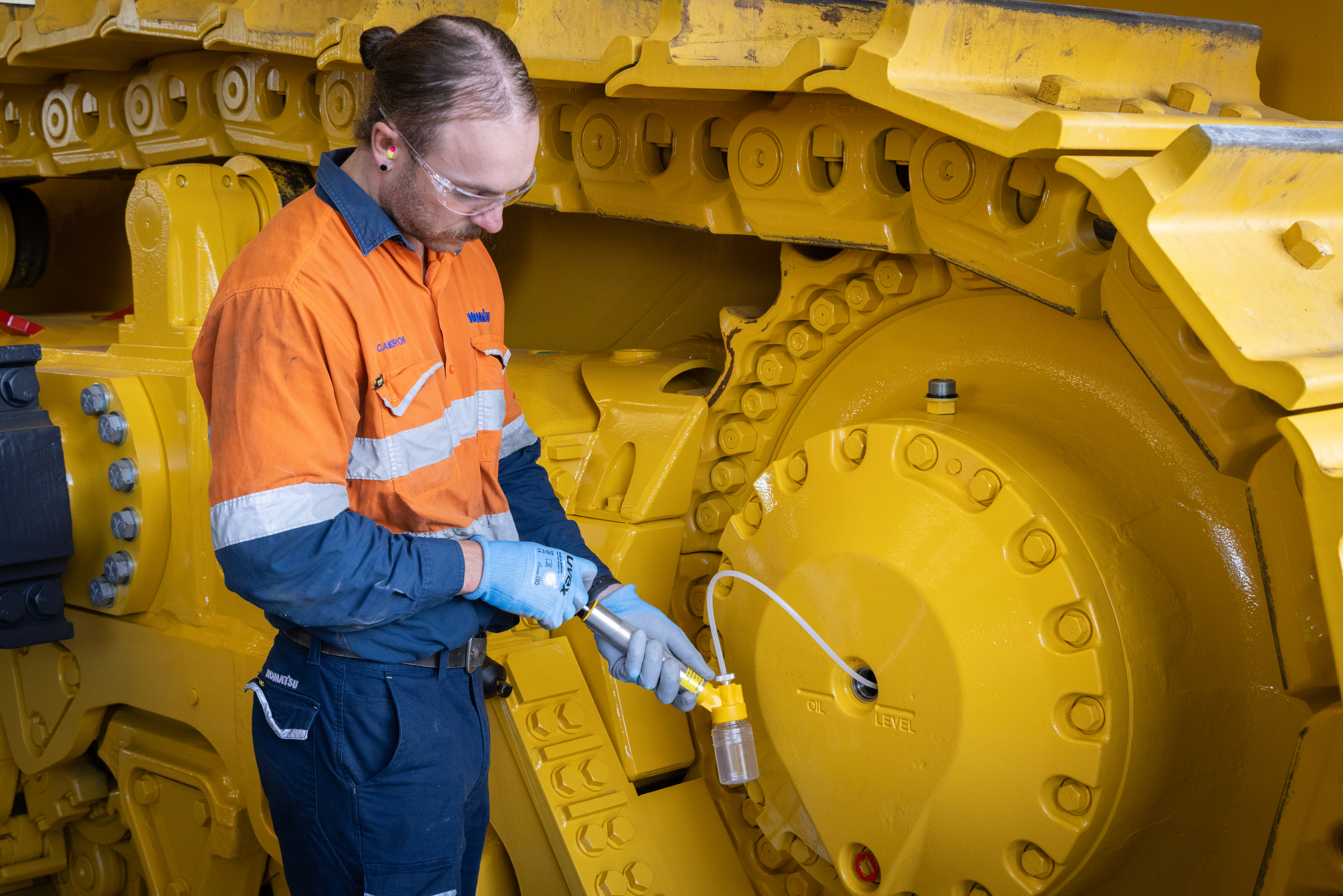 A man checking and giving maintenance to a Komatsu equipment