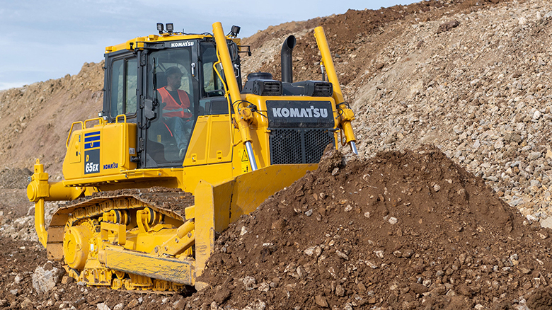 Komatsu D65ex excavator moving dirt on a job site.