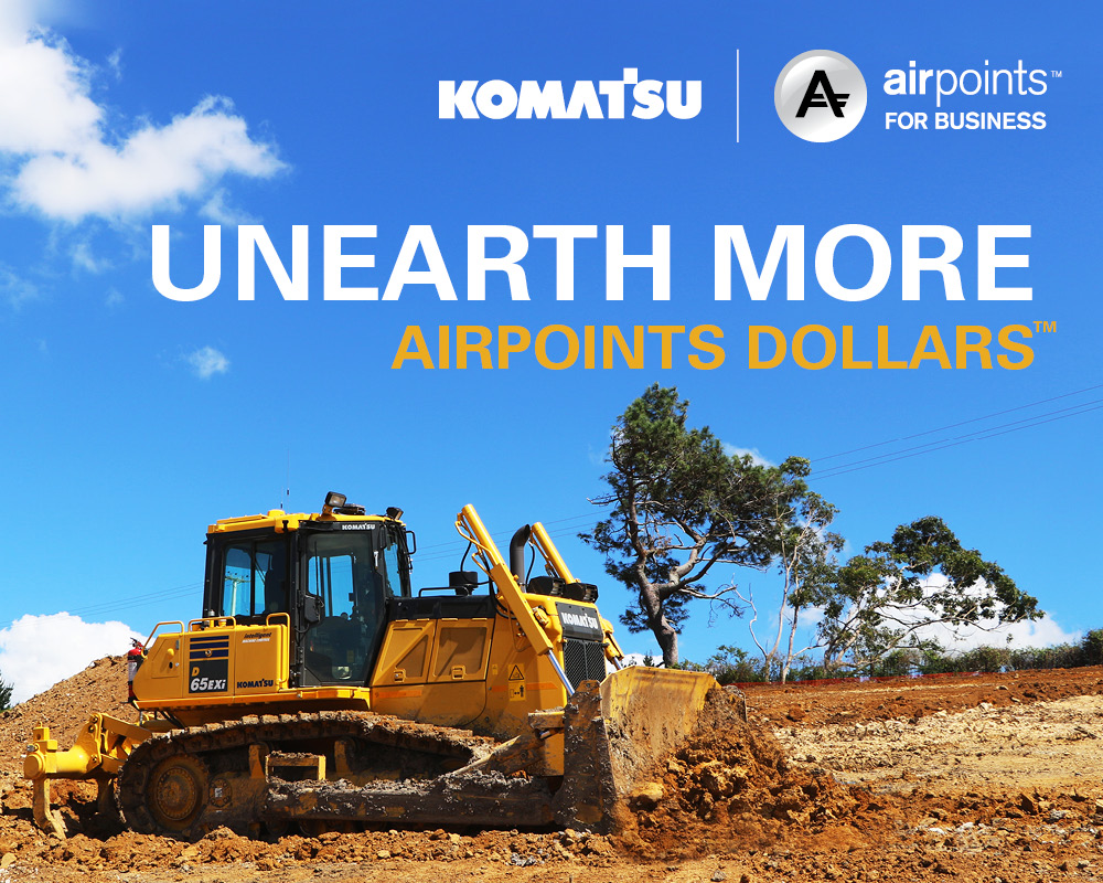 Promotional image featuring a Komatsu bulldozer at a construction site under a clear blue sky, with the text 'Unearth More Airpoints Dollars' displayed prominently, alongside logos for Komatsu and Airpoints for Business.